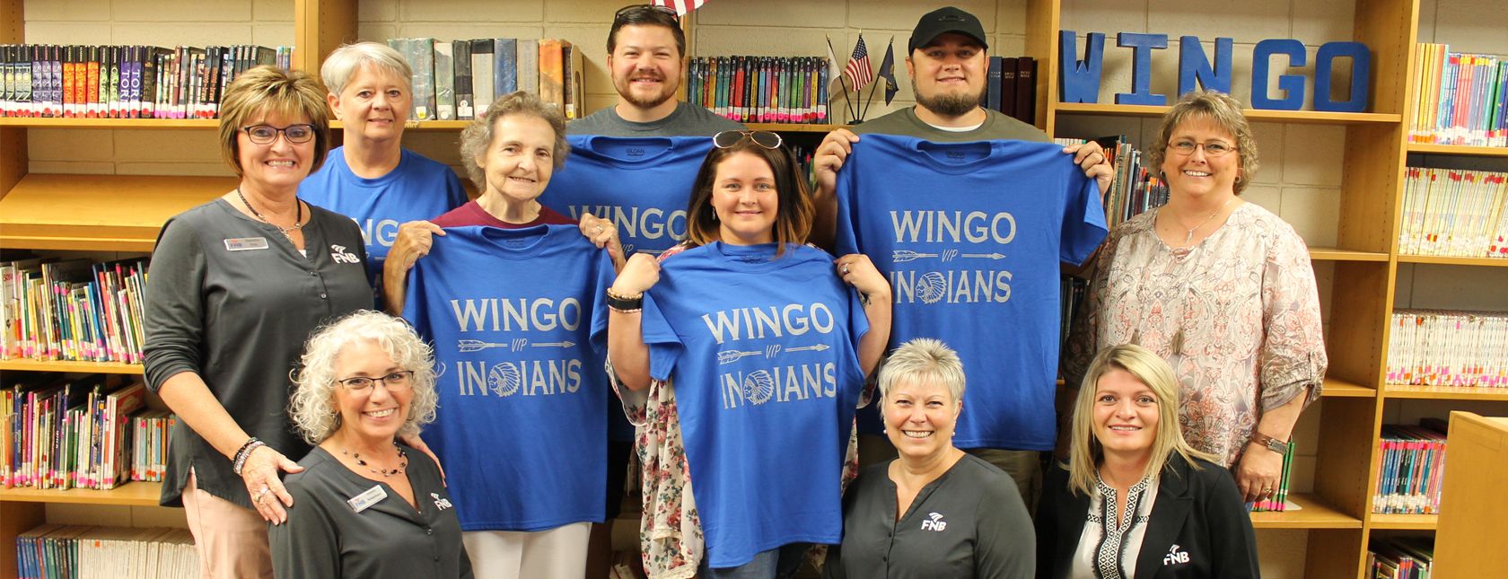 FNB bank employees with Wingo Indians friends holding up Wingo Indians shirts