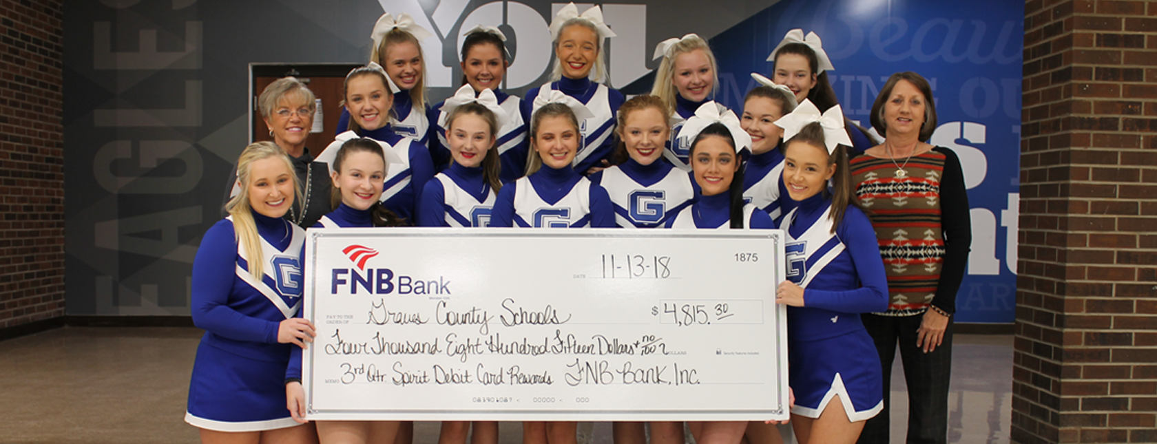 Graves County High School Cheerleaders holding the third quarter spirit debit card check